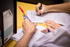 People filling in forms.